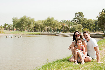 Image showing Family sitting near the lake