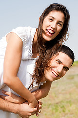 Image showing Smiling young couple piggybacking