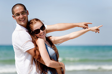 Image showing Couple smiling and pointing at the sea