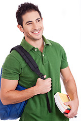 Image showing Smiling Young student carrying bag and books
