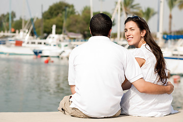 Image showing Rear view of young couple sitting at the harbour