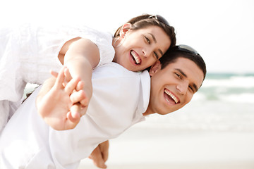 Image showing Young man piggybacking his girlfriend at beach