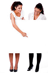 Image showing Full length of a Business woman pointing a blank board to her colleague