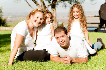 Image showing Family of four lying in grass