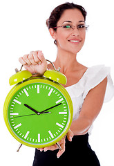 Image showing Young business woman showing a green color clock