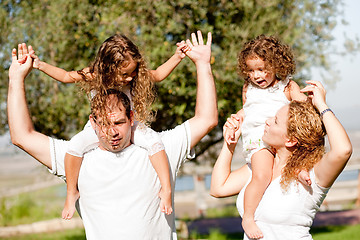 Image showing Daughters enjoying their ride on parents shoulders