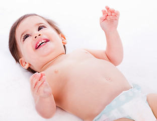 Image showing Playful baby lying with has hands up