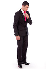 Image showing Business man bending his head down to fit his necktie