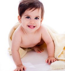 Image showing Baby showing its teeth under yellow towel