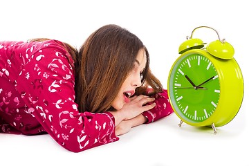 Image showing Girl looking into the alarm while its ringing