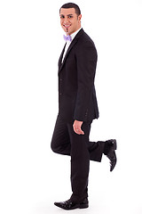 Image showing Full length of a business man leaning against the wall