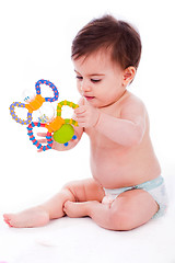 Image showing Baby sitting with diaper and playing with toys