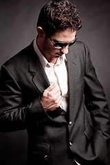 Image showing Young business man looking down wearing sunglasses