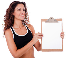 Image showing Fitness woman showing a blank clip board