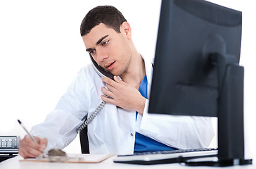 Image showing Doctor making notes of the conversation over phone