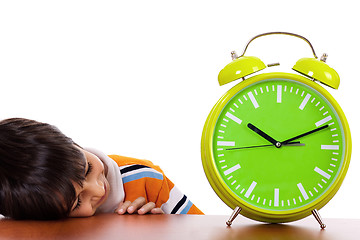 Image showing Boy tired of study and sleeping near the clock