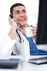 Image showing Smiling young doctor over phone