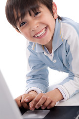 Image showing Portrait of cute caucasian boy smiling with laptop