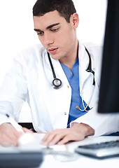 Image showing Handsome doctor making notes from the computer