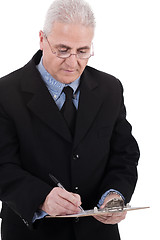 Image showing Confident senior business man writing on the clipboard