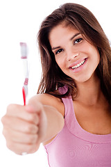 Image showing beautiful young woman holding toothbrush and smiling