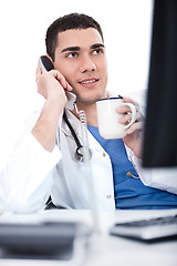 Image showing Portrait of young doctor talking over telephone and having coffee