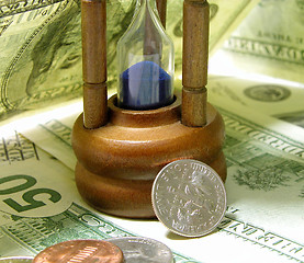 Image showing time: hourglass and shadows...money:the bills...interesting objects and lighting business composition