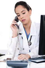 Image showing Beautiful female doctor trying the phone very seriously