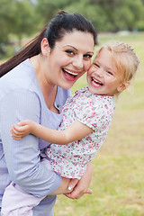 Image showing Curious mother carrying her daughter with big smile