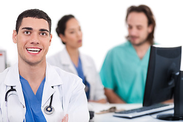 Image showing Happy young doctor in focus, two others in out of focus