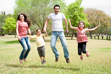 Image showing Family jumping together in the park