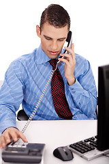 Image showing young business man sitting at his desk talking over phone