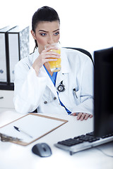 Image showing Doctor drinking a glass of juice at her workplace