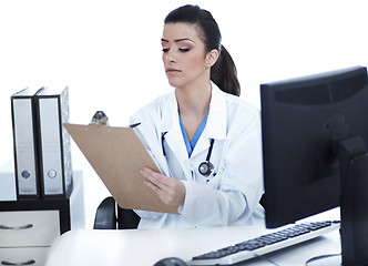 Image showing Doctor woman sitting on her office making notes