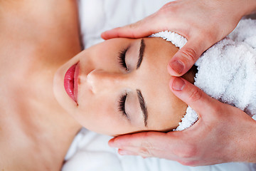 Image showing Young pretty girl getting face massage in spa