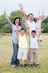 Image showing Happy family on outdoors  enjoying by raising hands