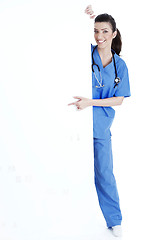 Image showing Smiling young nurse pointing blank board