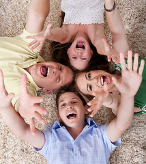 Image showing happy family lying with their heads close together and shouting