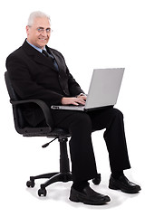 Image showing Busy senior business man sitting in chair
