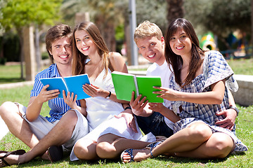 Image showing Smiling young couple holding books posing to camera