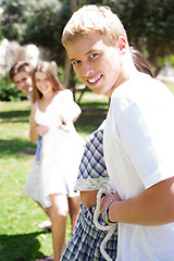 Image showing Happy Friends pulling a rope against each other