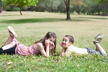 Image showing Cute children lie down on green grass