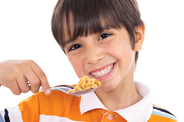 Image showing Smiling young boy with spoon of flakes, closeup