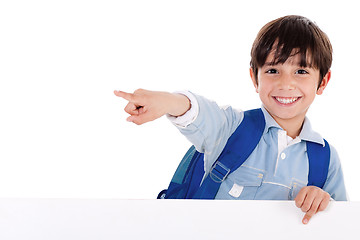 Image showing Smiling young boy standing behind the blank board and pointing us