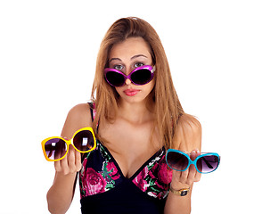 Image showing Young woman holding different colors of sunglasses