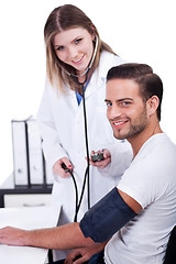 Image showing Female doctor checking blood pressure