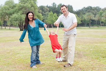 Image showing Happy couple playing on the green park with their beautiful daughter