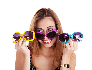 Image showing young smiling woman holding different colors of sun glasses