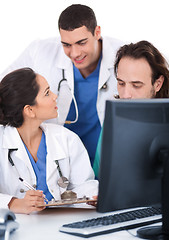 Image showing Young doctors team discussing and making notes from computer