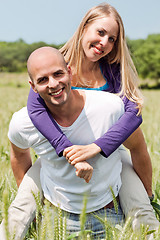 Image showing Two young lovers holding each other piggyback